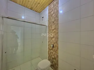 Imagem de um banheiro com box de vidro e revestimento de parede.