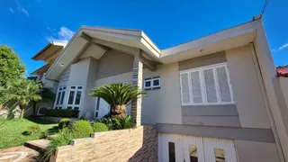 Fachada de uma casa residencial em Lajeado, Brasil, com paredes claras e paisagismo frontal.