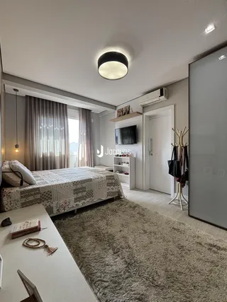 Quarto com cama e cortinas em um apartamento em Lajeado.