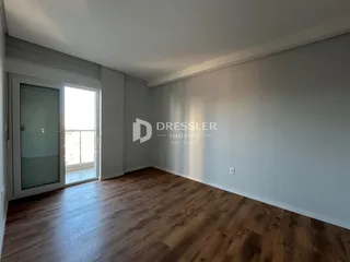 Sala de estar com piso de madeira e porta de vidro.