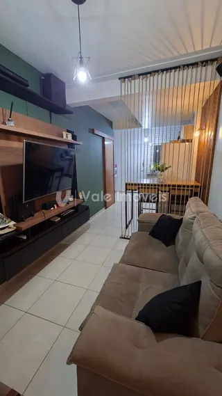 Sala de estar com sofá e televisão em um imóvel no Brasil.