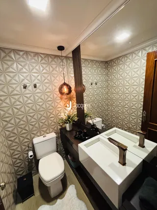 Banheiro com dois vasos sanitários e uma bancada dupla moderna.