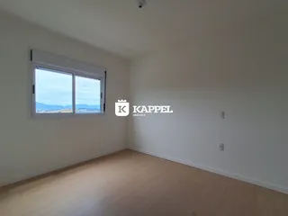 Uma sala de estar clara com grande janela oferecendo uma vista externa.