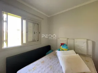 Quarto com janela e cabeceira branca em um imóvel no Brasil.