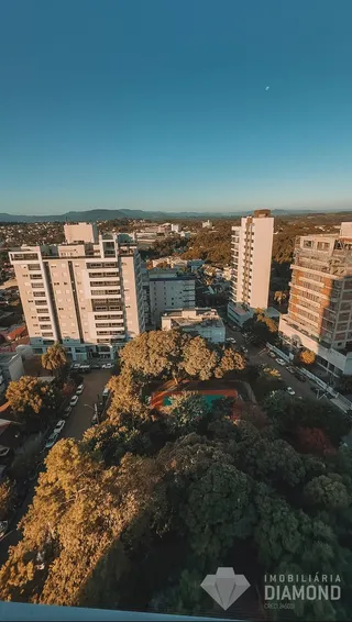Vista aérea de um bairro residencial em Lajeado, Brasil, mostrando edifícios e vegetação.