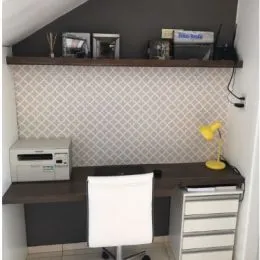 Foto de um escritório com prateleira de madeira e parede texturizada.