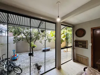 Vista da sala de estar com portas de vidro que dão acesso a um pátio externo.