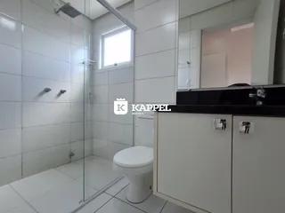 Banheiro com piso de cerâmica e box de vidro.