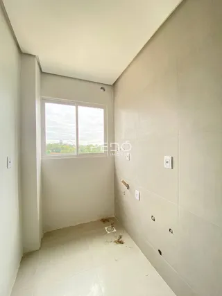 Vista interna de um corredor com paredes brancas e piso de cerâmica.
