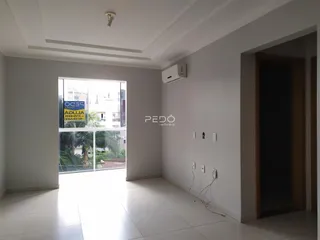 Interior de um corredor com piso de cerâmica e parede branca.