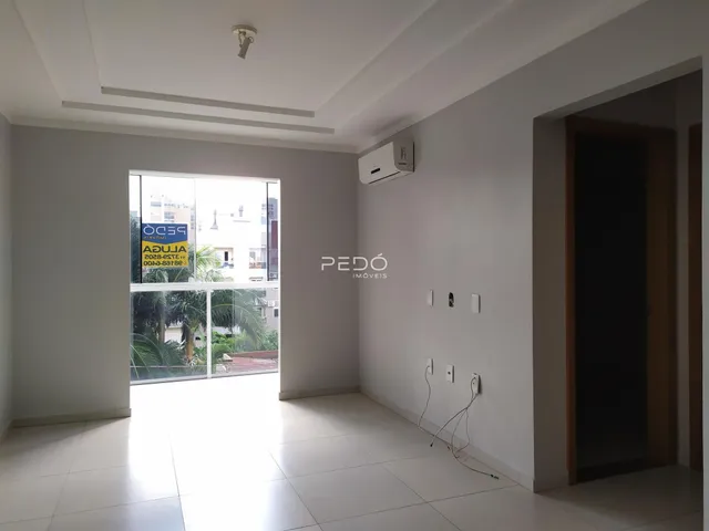 Interior de um corredor com piso de cerâmica e parede branca.