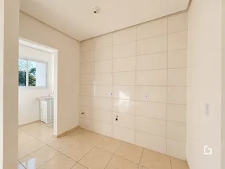 Hall de entrada com piso de cerâmica claro e paredes claras.