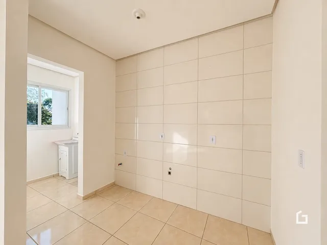 Hall de entrada com piso de cerâmica claro e paredes claras.