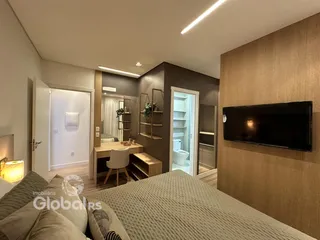 Quarto com cama e televisão em ambiente moderno.