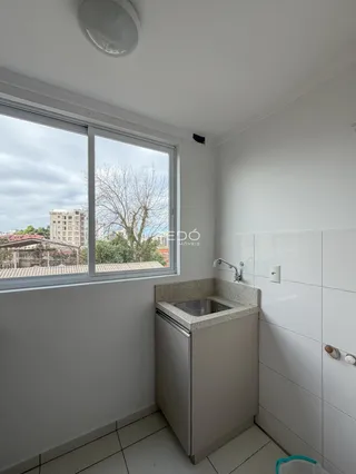Foto de um banheiro com janela e revestimento branco.