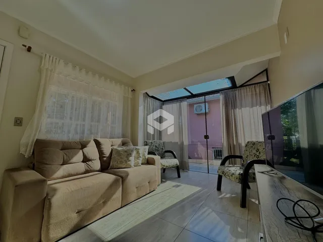 Sala de estar com sofá e decoração clara em um imóvel no Brasil.