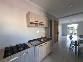 Vista da cozinha com armários de madeira e bancada.