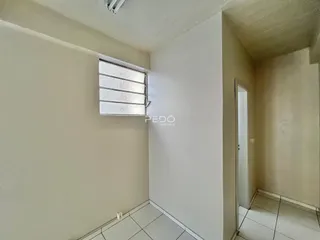 Vista interna de um corredor com piso de cerâmica branca.