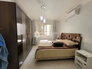 Quarto com cama de madeira e armário em um apartamento.