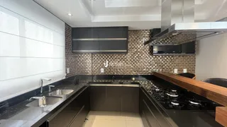 Esta é uma foto de uma cozinha moderna com armários escuros e revestimento de tijolos.