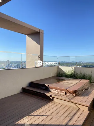 Varanda com piso de madeira e vista panorâmica da cidade.