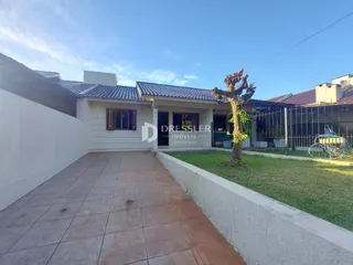 Fachada de casa com pátio e jardim.