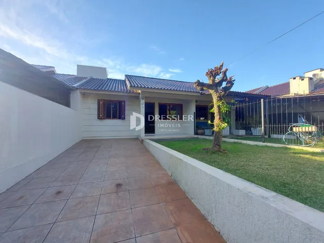Fachada de casa com pátio e jardim.