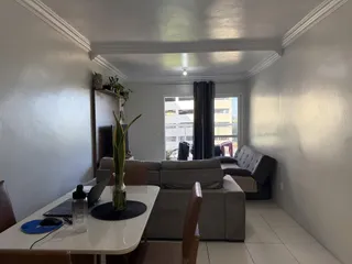 Foto de uma sala de estar com sofá e mesa de jantar.