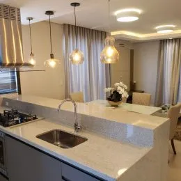 Vista de uma bancada de cozinha com armários e iluminação clara.
