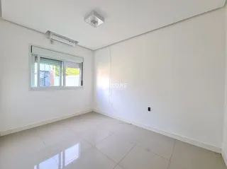 Ambiente interno de uma sala com paredes brancas e piso claro.