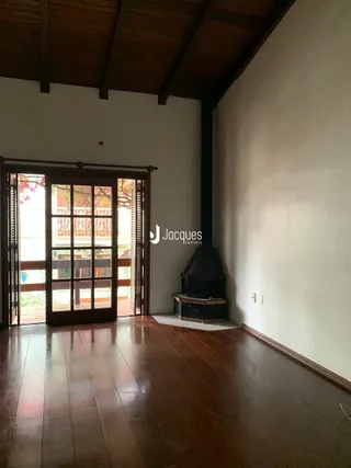 Interior com piso de madeira e vigas expostas.