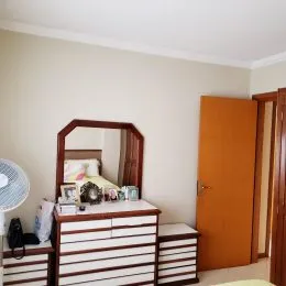 Foto de um armário de madeira com espelho em um ambiente interno.