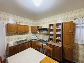 Foto interna de uma cozinha com armários de madeira e bancada.