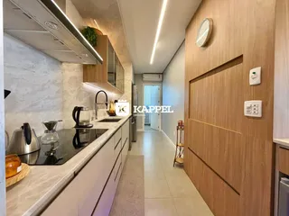 Cozinha moderna com bancadas claras e armários em madeira.