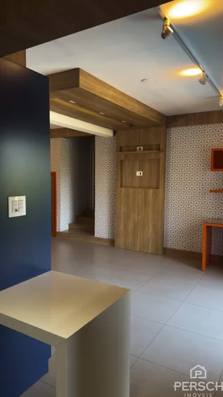 Interior de uma sala com painéis de madeira e papel de parede texturizado.