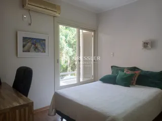 Quarto com cama e janela de vidro.