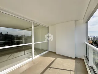 Vista de uma sala de estar com portas de vidro que se abre para uma varanda.