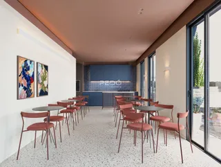 Ambiente interno de uma sala de jantar com mesas e cadeiras.