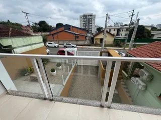 Vista de uma varanda com piso de ladrilhos olhando para um bairro residencial.