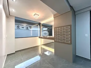 Corredor interno com piso de mármore polido e portas numeradas