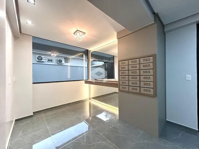 Corredor interno com piso de mármore polido e portas numeradas