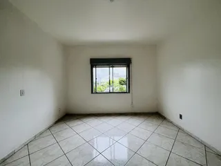 Esta é uma vista interna de um cômodo com piso de cerâmica e uma janela grande.