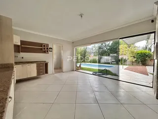 Sala de estar com portas de vidro que se abrem para uma área externa com piscina.