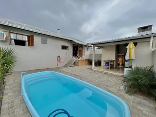 Foto da fachada de uma casa com piscina no exterior.