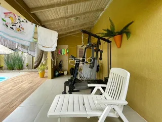 Ambiente interno de uma sala com piso de madeira e parede amarela.
