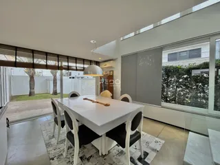 Vista de uma sala de jantar com mesa e cadeiras em um imóvel no Brasil.