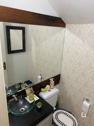 Foto de um banheiro interno com pia e vaso sanitário.