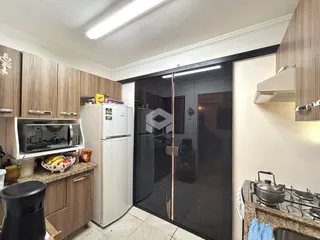 Interior da cozinha com armários de madeira e eletrodomésticos brancos.