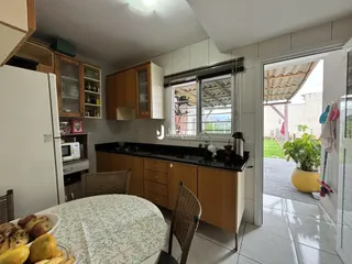 Foto de uma cozinha com armários de madeira e acesso a uma área externa.