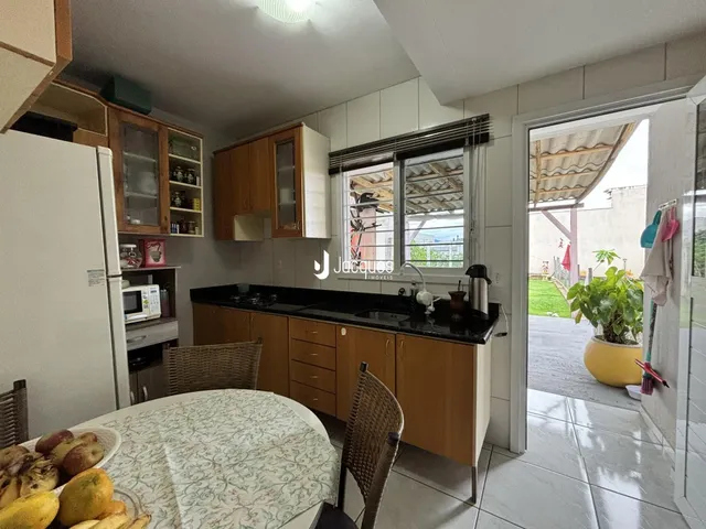 Foto de uma cozinha com armários de madeira e acesso a uma área externa.